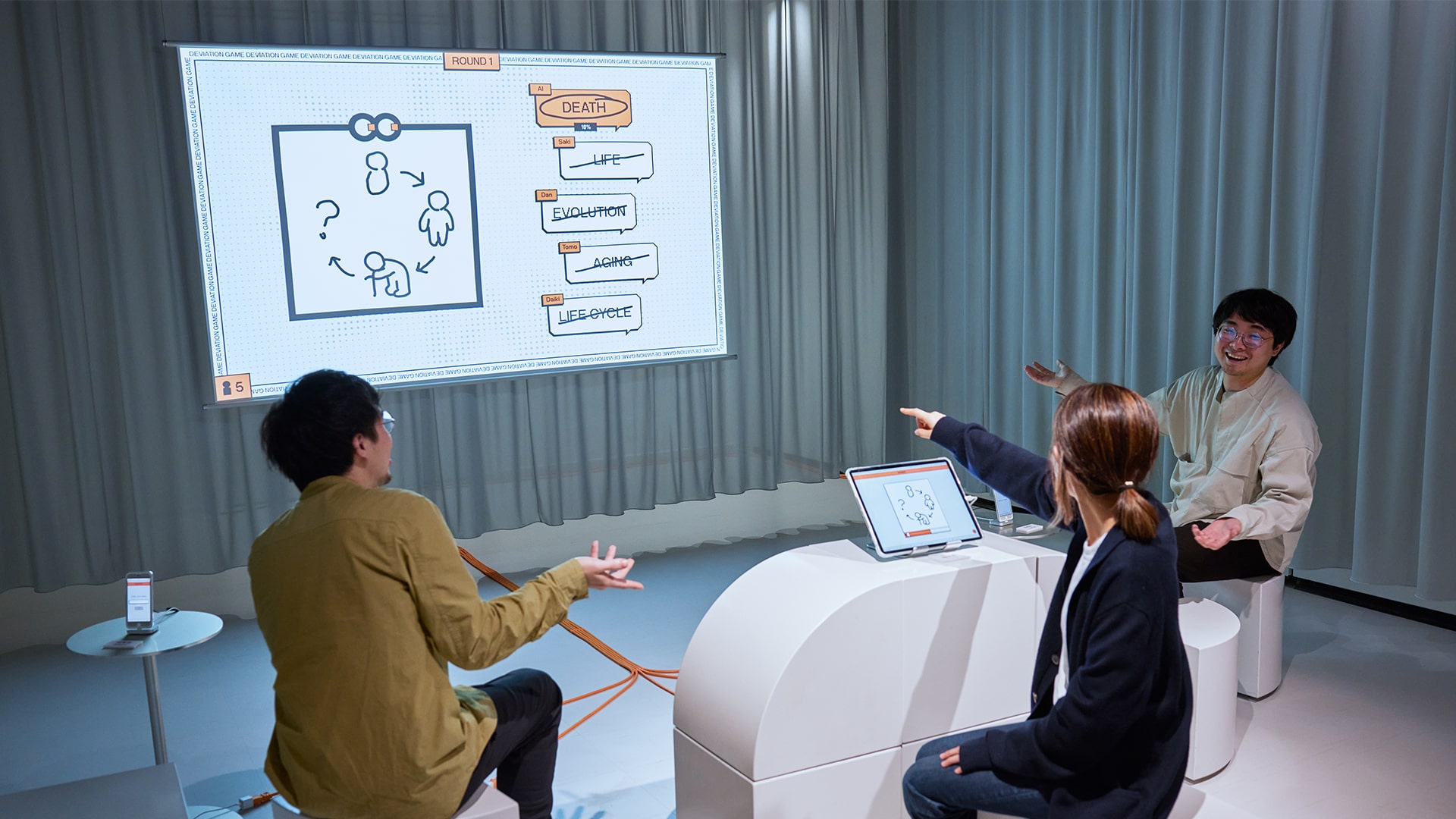 Deviation Game CCBT exhibition. People pointing and enjoying the game.